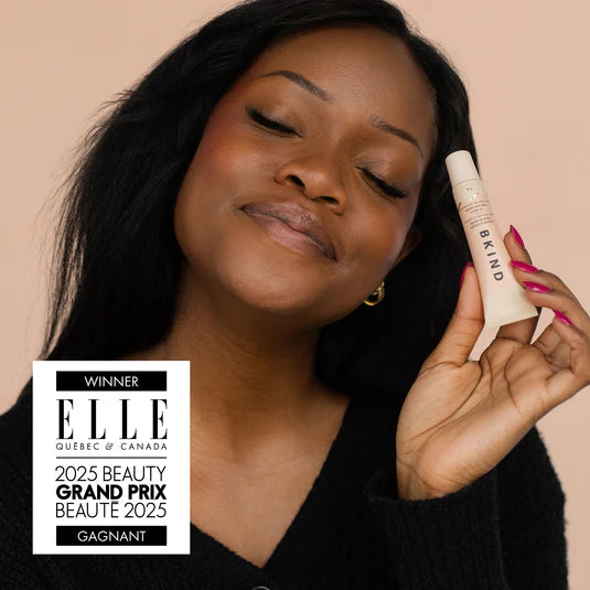 Woman smiling while holding BKIND pear and vanilla lip balm — Lemonberry Aurora