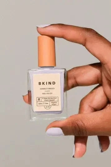 Model holding a bottle of Bkind's Run the World colour Nail Polish.