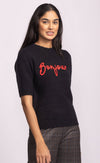 Side view of black Pink Martini Bonjour Sweater showing relaxed fit and red embroidered lettering – Lemonberry women’s knitwear.