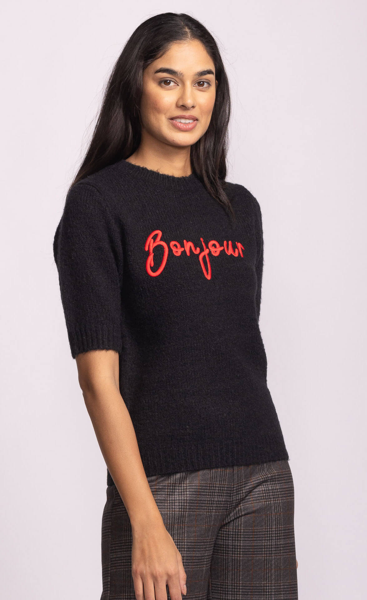 Side view of black Pink Martini Bonjour Sweater showing relaxed fit and red embroidered lettering – Lemonberry women’s knitwear.
