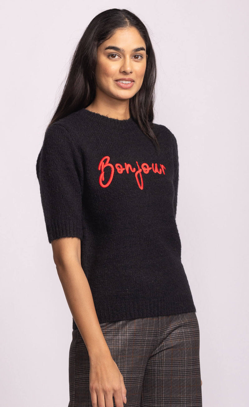 Side view of black Pink Martini Bonjour Sweater showing relaxed fit and red embroidered lettering – Lemonberry women’s knitwear.