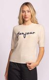 Close-up of beige Pink Martini Bonjour Sweater showing navy embroidered script detail – soft knit available at Lemonberry.