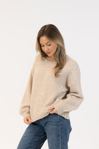 Model looking down with sweater gently tucked in jeans

