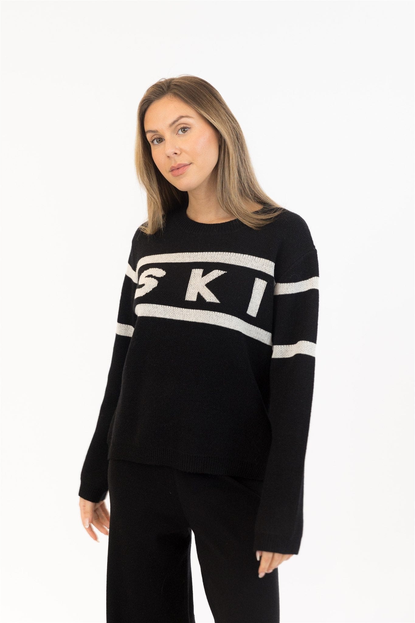 Close-up of SKI graphic on black knit sweater with ribbed cuffs

