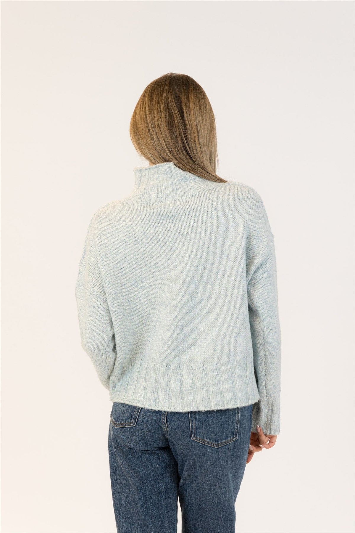 Woman wearing Calli sweater by Lyla and Luxe with blue jeans on a white background