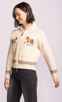 Side view of Capella Sweater showing horse embroidery and heritage knit cuffs