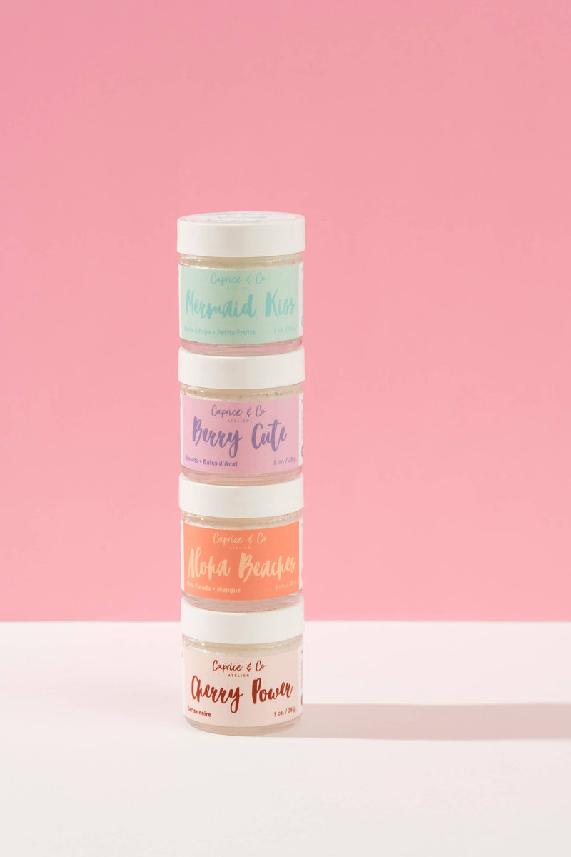 Caprice & Co lip scrubs stacked vertically in assorted flavours on a soft pink background, Lemonberry Aurora