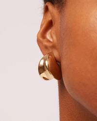Close up of the Paige Puff Earrings by Jenny Bird on a models ear. 