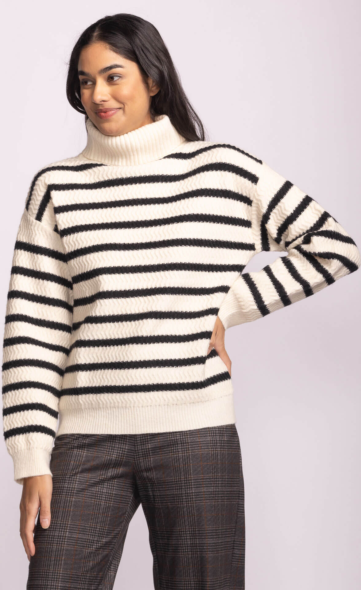 Model wearing Pink Martini Corsica Sweater in cream with black stripes, front view.