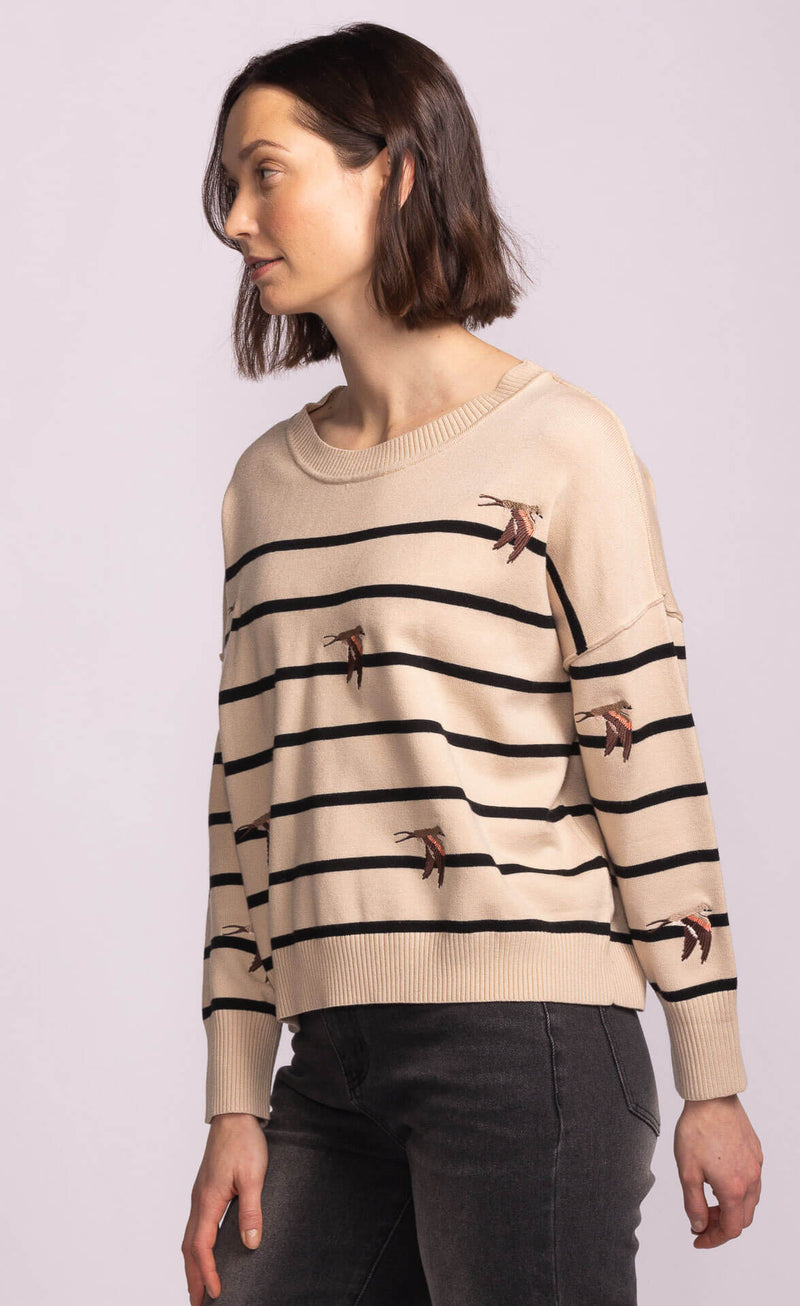 Side view of the Cruz Sweater in beige with black stripes and swallow embroidery, relaxed fit from Lemonberry.