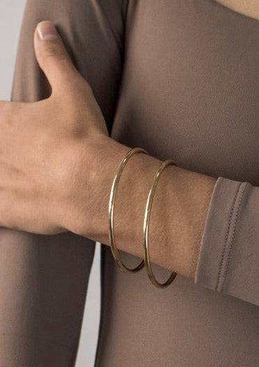 Gold Dane Bangle worn with taupe long-sleeve top — styled for everyday simplicity in Aurora, ON