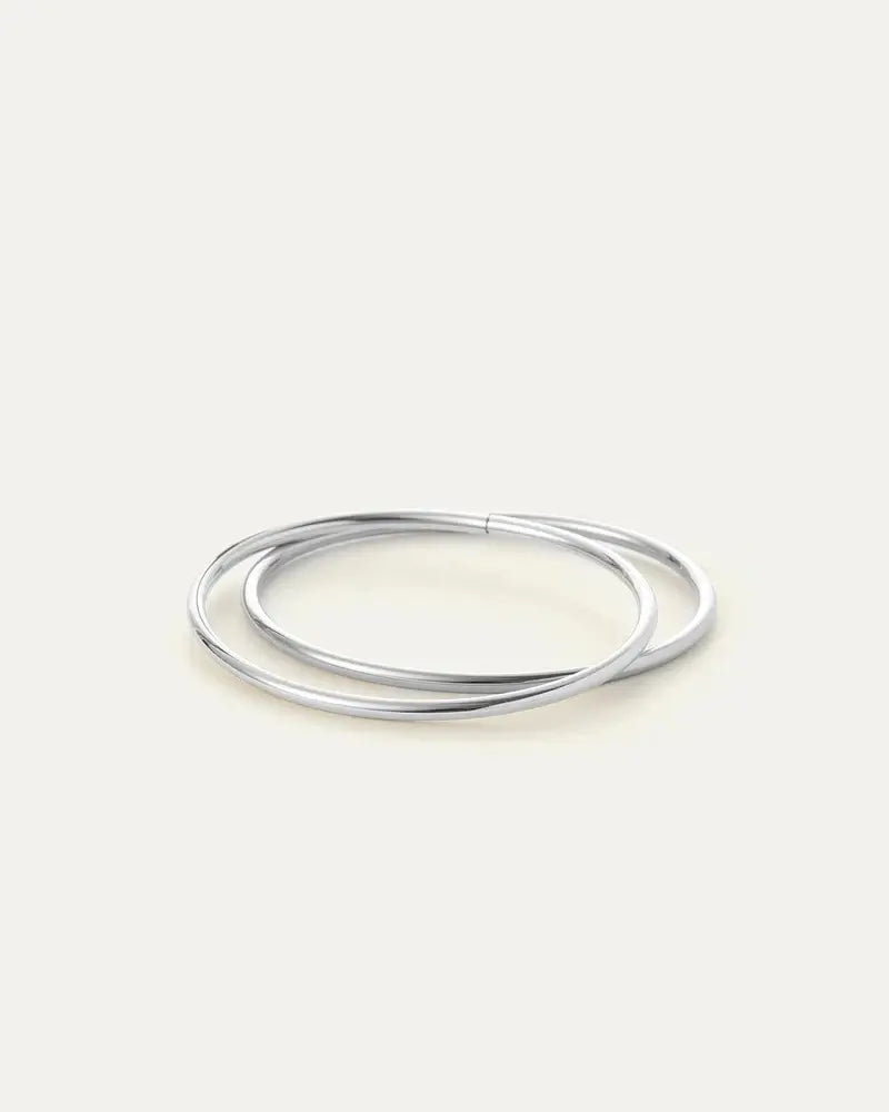 Flat lay of silver Dane Bangle — rhodium finish with hinge detail