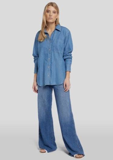 Full front view of the 7 For All Mankind Denim Shirt in medium blue wash, featuring a classic design with a front chest pocket and dolphin hem for a polished look.

