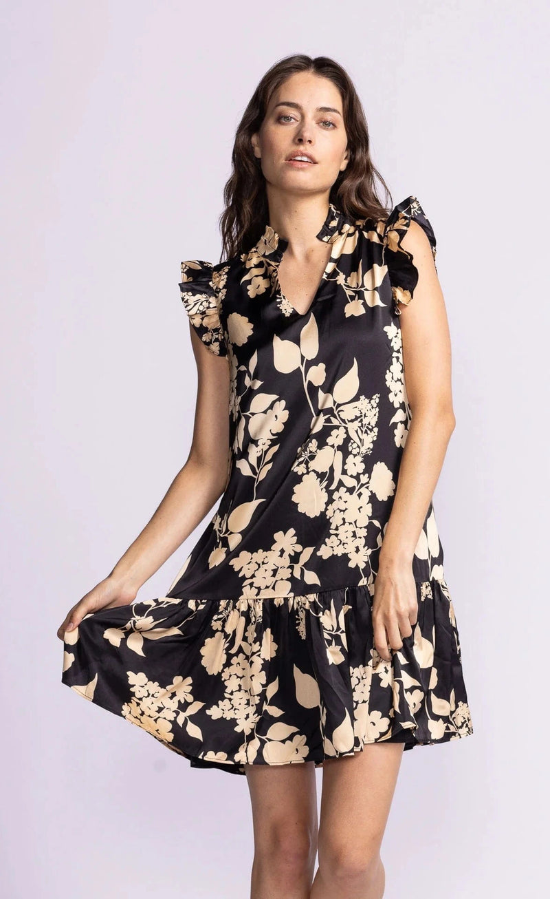 The Dina Dress by Pink Martini, worn by a model displaying the cute flower print and ruffled sleeves.