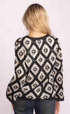 Back view of Dina Sweater in crochet knit, black and cream diamond pattern