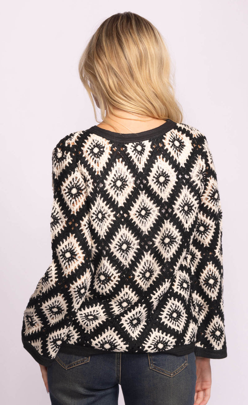 Back view of Dina Sweater in crochet knit, black and cream diamond pattern