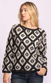 Woman wearing Dina Sweater by Pink Martini, black and cream crochet knit, styled with jeans