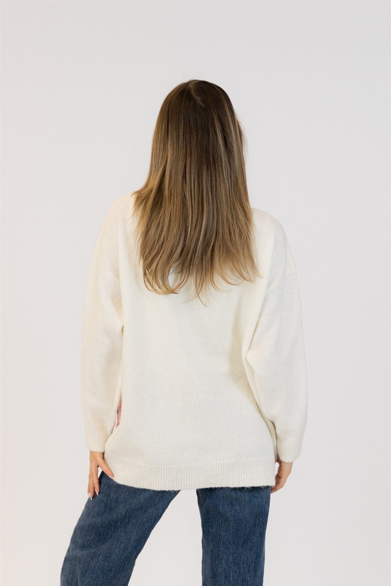 Back view of the Elska cardigan by Lyla & Luxe in white, showing clean, flower-free knit across the back.