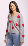 Side view of grey Espera Sweater with bold red hearts and drop shoulders