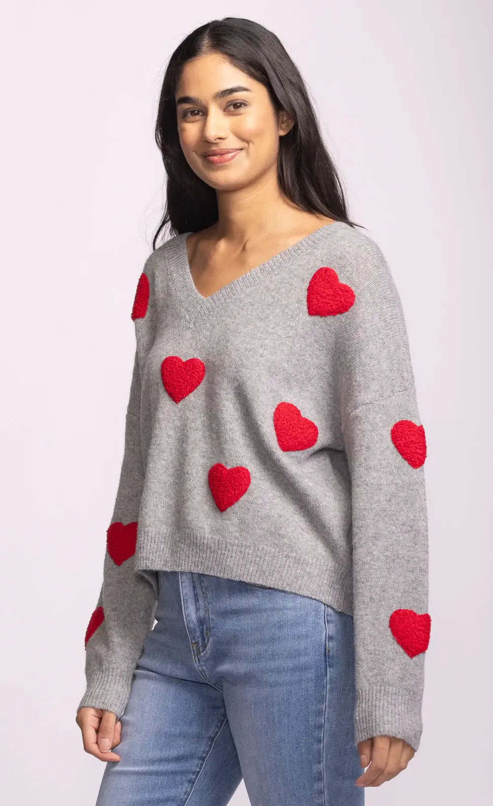 Side view of grey Espera Sweater with bold red hearts and drop shoulders
