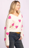 Side view of Espera Sweater in white with playful pink hearts and relaxed fit