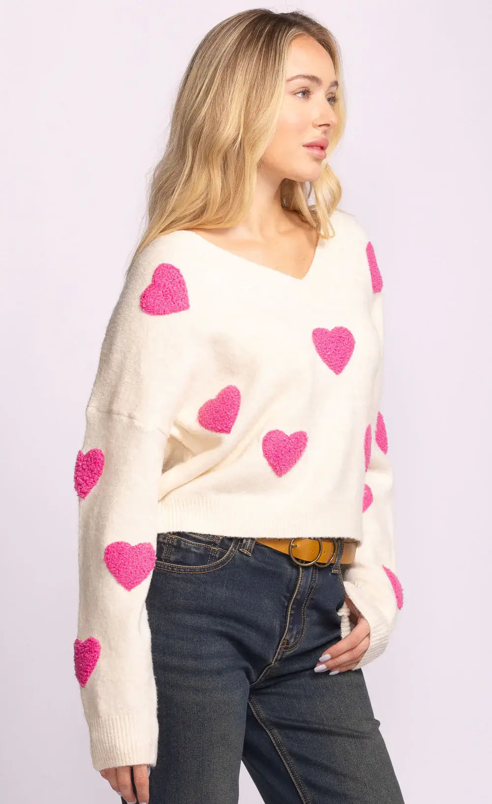Side view of Espera Sweater in white with playful pink hearts and relaxed fit