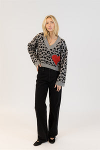 Woman wearing Lyla & Luxe Elska cardigan in pale blue with navy heart print, standing against a white background – available at Lemonberry in Aurora, ON

