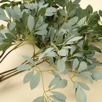 Close-up of faux olive leaf branch showing realistic leaf shape and muted green tones, Lemonberry Aurora