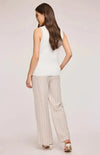 Back view of the Findley Pant by Gentle Fawn, worn by a model in a white vest and white open toe shoes.