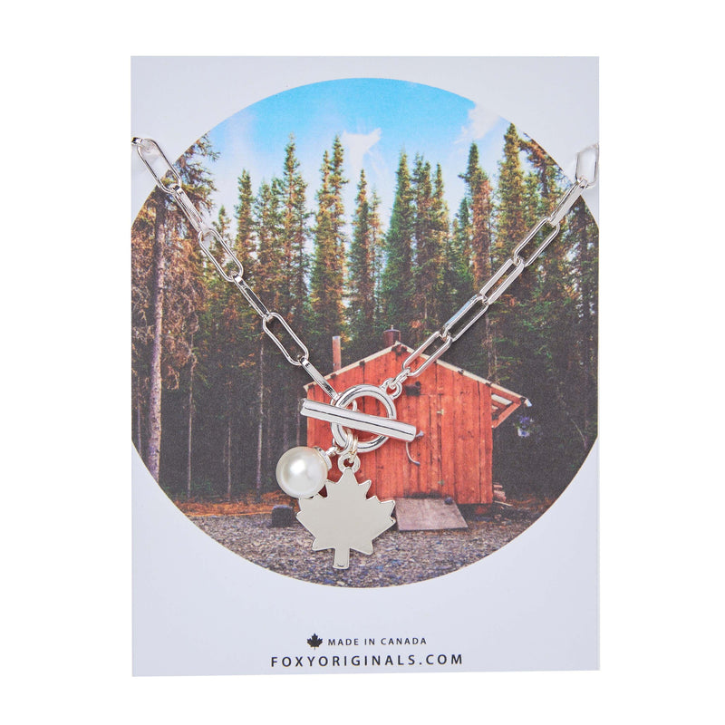 Maple Leaf Toggle Necklace in silver with pearl charm – displayed on card with forest cabin design by Foxy Originals