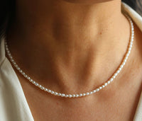 Petite pearl necklace worn on neck with shite shirt, Luna, worn view — Lemonberry Aurora