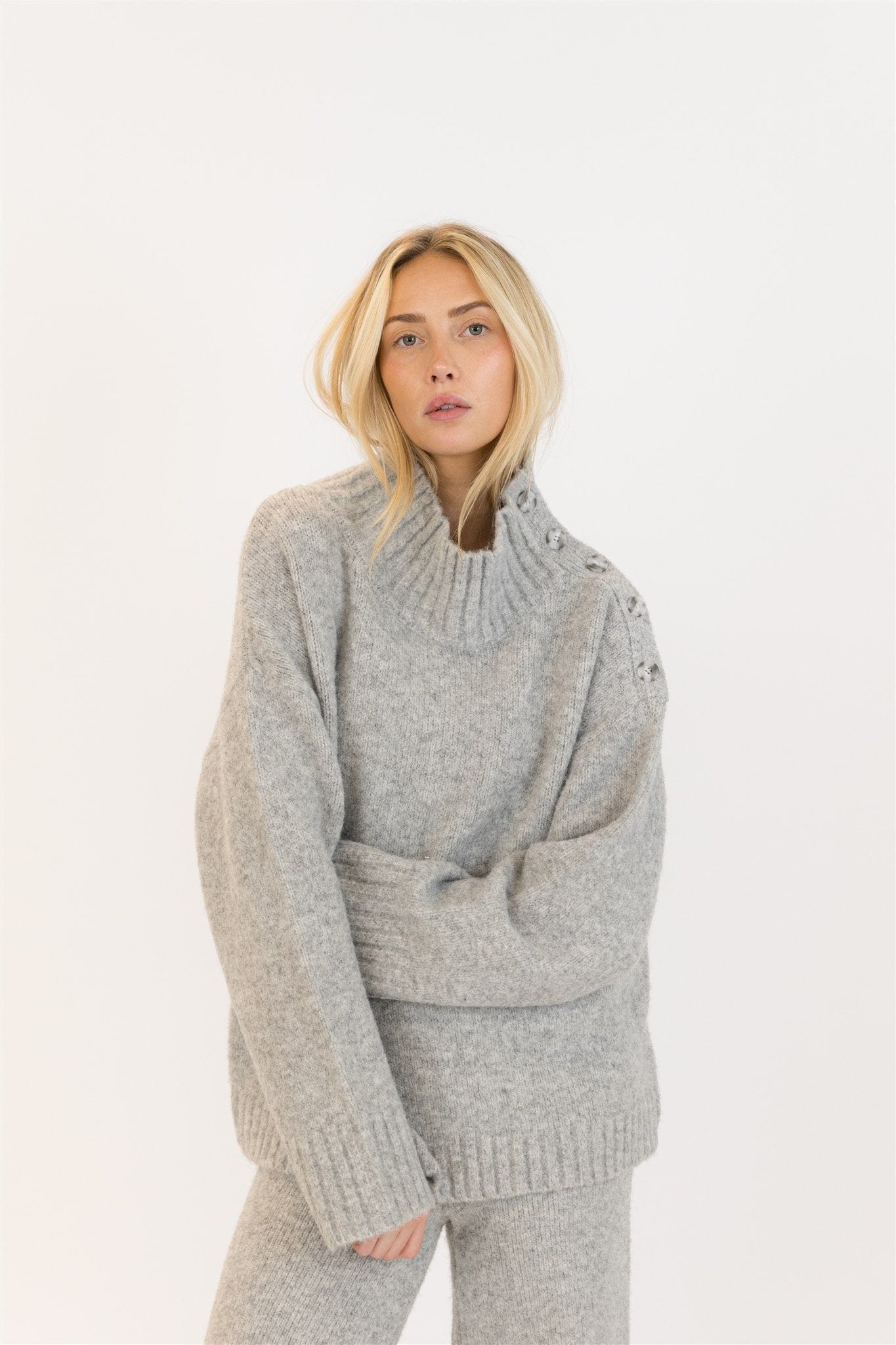 Front view of woman in GANTLUXE Heather Grey sweater and pants set, studio background