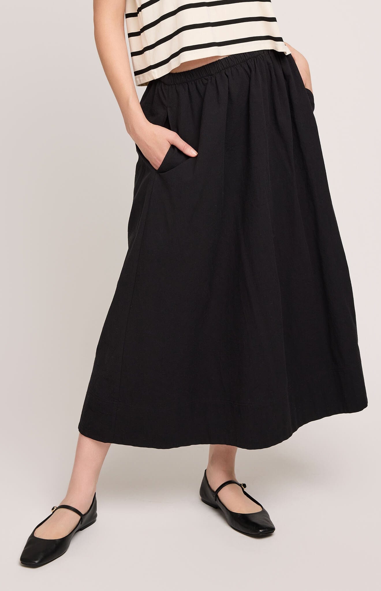 Close-up of Gentle Fawn Geneva Skirt in black showing elastic waistband and inseam pockets.

