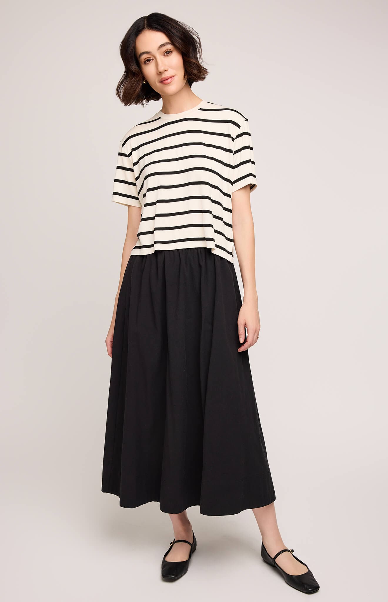 Front view of model wearing Gentle Fawn Geneva Skirt in black, styled with striped top – King City Locale reference.
