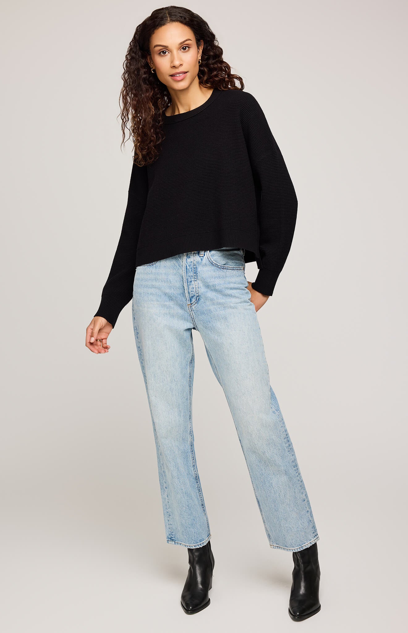 Front view of model wearing Gentle Fawn Axel Sweater in black, styled with light-wash jeans and black boots – Aurora Aw, Shucks Seafood Bar reference.