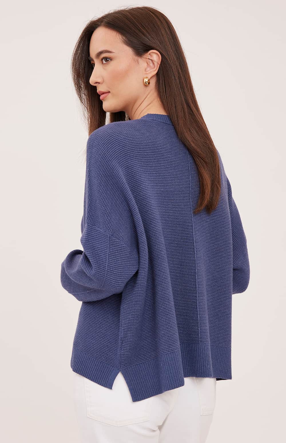 Back view of the Gentle Fawn Axel sweater in Heather Navy showing its textured knit and side slits
