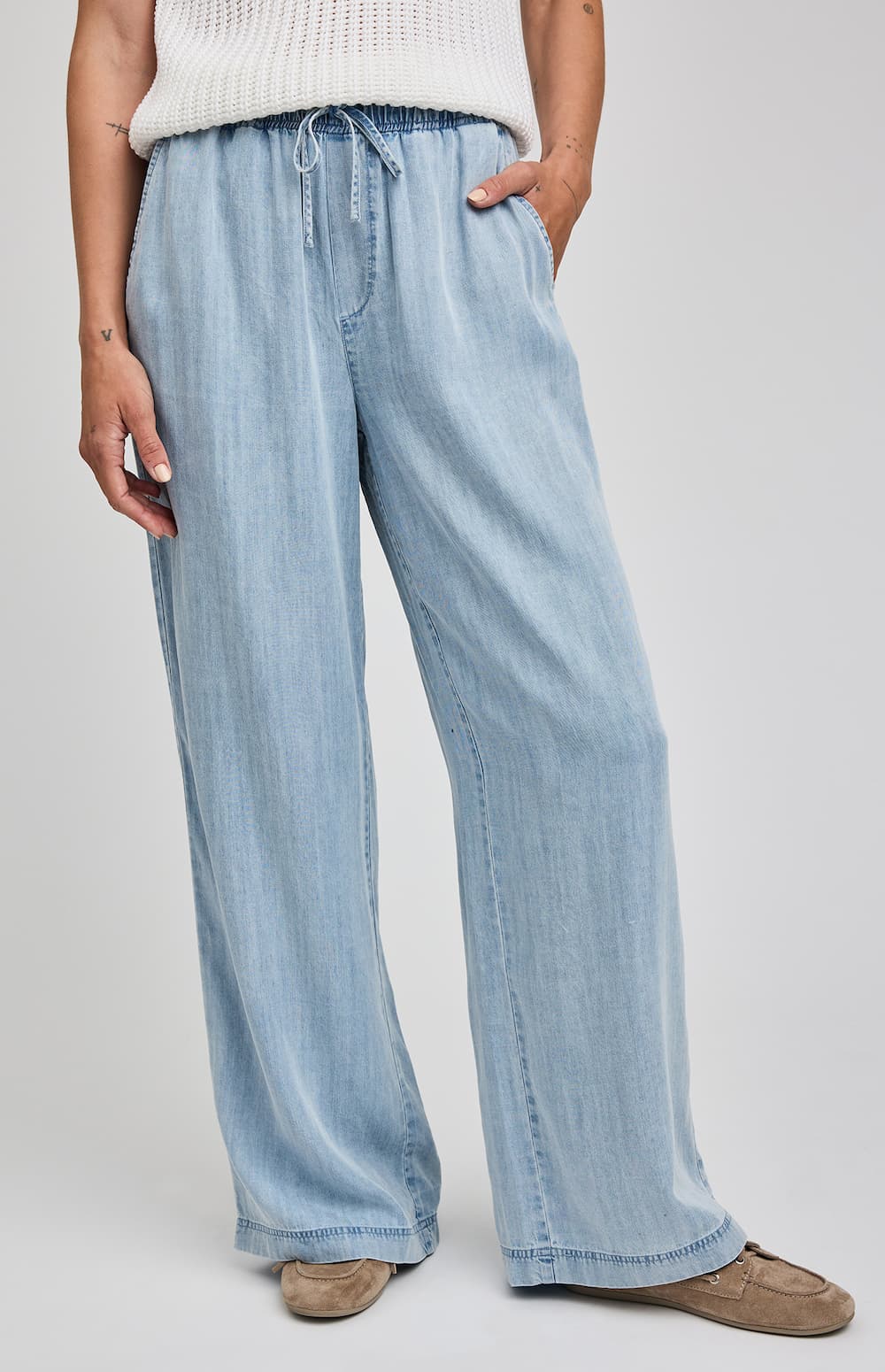 Light blue denim pants worn by a person on a plain background