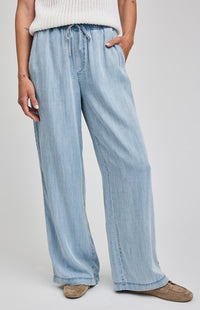 Light blue denim pants worn by a person on a plain background