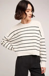 Woman wearing Gentle Fawn's cream and black striped oversized Echo sweater with black shorts on neutral background