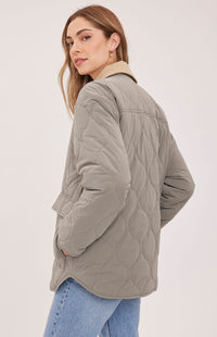 Back view of the Gentle Fawn Felix quilted jacket in Mineral showing its curved quilting and relaxed fit
