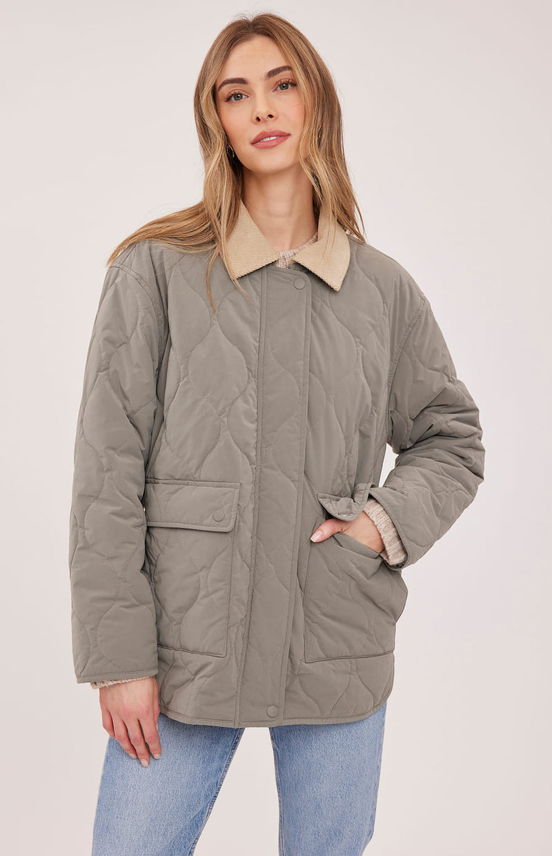Closed front view of the Gentle Fawn Felix quilted jacket in Mineral showing its pockets and snap placket
