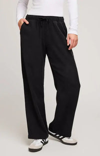 Model wearing black wide-leg Gabriel Pant by Gentle Fawn, styled with a white fitted top and sneakers – front view.