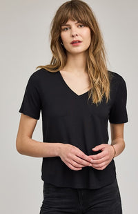 Woman wearing a black V-neck t-shirt against a plain background