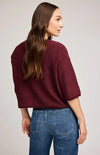 Back view of burgundy Gentle Fawn Kerrigan sweater showing rolled hem and loose fit, worn with medium-wash jeans.