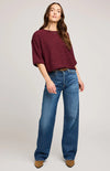 Full-body view of woman in Gentle Fawn Kerrigan sweater and wide-leg denim, standing casually against pale backdrop.