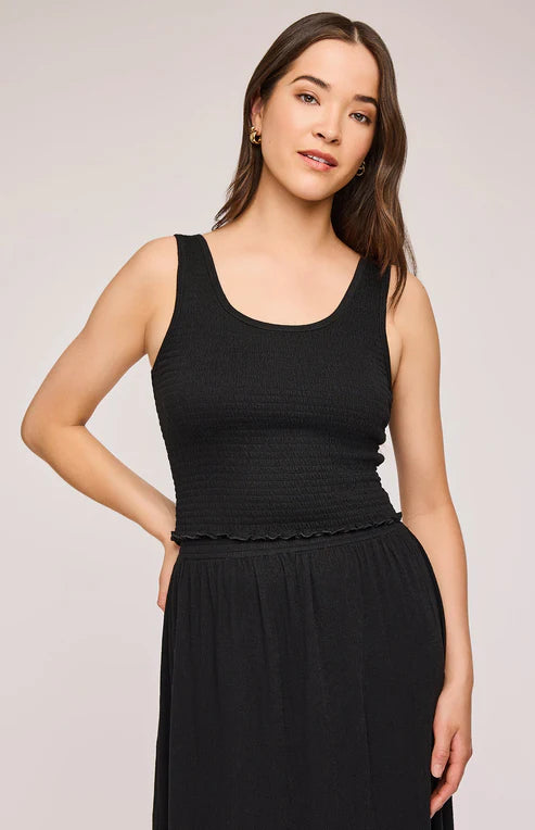 Model wearing the Gentle Fawn Layla Tank in black, front view. Features a smocked bodice, scoop neckline, and ruffled hem.