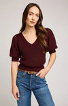 Woman wearing burgundy puff-sleeve Phoebe sweater by Gentle Fawn with blue jeans – front view