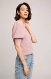Woman wearing Gentle Fawn's Phoebe sweater and light blue jeans on a plain background