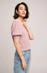 Woman wearing Gentle Fawn's Phoebe sweater and light blue jeans on a plain background
