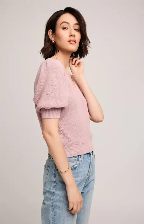 Woman wearing Gentle Fawn's Phoebe sweater and light blue jeans on a plain background